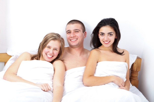Smiling Threesome in Bed